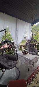 a patio with two chairs and a table and a white tent at Apartman Nina in Visoko