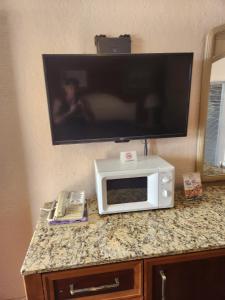 a microwave sitting on a counter with a tv on it at Sands Motel in El Paso