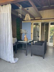patio ze stołem i krzesłami na ganku w obiekcie MARINA SUR L'ILE DES PECHEURS AVEC COMPLEXE AQUATIQUE w mieście Le Barcarès