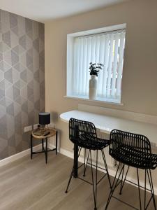 a kitchen with two chairs and a table and a window at Chapel Court Apartments in Cannock