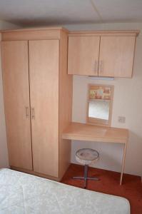 ein Schlafzimmer mit einem Schreibtisch und einem Stuhl neben einem Bett in der Unterkunft Plaża Pieniny - domki holenderskie in Czorsztyn