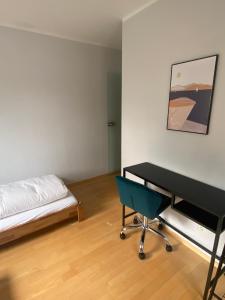 a bedroom with a bed and a desk and a chair at Bayern Lodge Bergen in Bergen