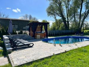 a backyard with a swimming pool and a gazebo at Black Horse in Pasłęk