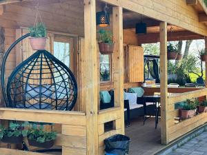 a wooden house with a bird cage on a deck at Black Horse in Pasłęk