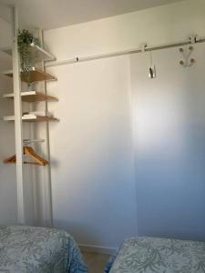 um quarto com uma cama e uma parede branca em Cabourg, appartement T2 accès direct mer em Cabourg