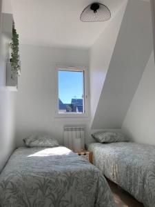 um quarto com 2 camas e uma janela em Cabourg, appartement T2 accès direct mer em Cabourg