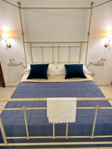 um quarto com uma cama com lençóis e almofadas azuis em Lo Scrigno Barocco em Lecce