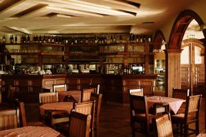 um restaurante com mesas e cadeiras e um bar em Hotel Etno Centar Balasevic em Boljevac