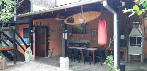 a restaurant with tables and chairs in a building at Aldeia Itamambuca Chalé Camping Ubatuba in Ubatuba