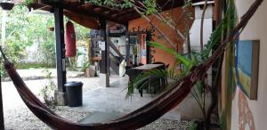 a hammock hanging from the side of a building at Aldeia Itamambuca Chalé Camping Ubatuba in Ubatuba