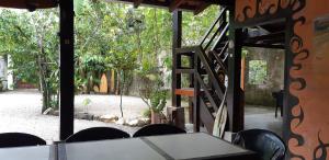 a table and chairs with a view of a garden at Aldeia Itamambuca Chalé Camping Ubatuba in Ubatuba