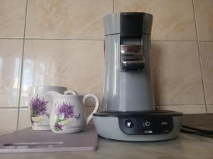 Una cafetera y dos tazas en un mostrador en Apartman Leona, en Rogoznica