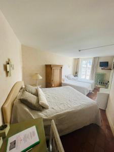 a bedroom with a large bed and a window at Hotel de la Sologne in Beaugency