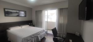 een hotelkamer met een bed en een raam bij Apartamento San Diego Pampulha Propriedade Particular in Belo Horizonte