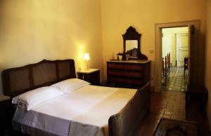 a bedroom with a bed and a dresser and a mirror at La Corte in Foligno