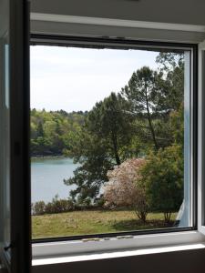 - une fenêtre avec vue sur le lac et les arbres dans l'établissement Villa Kerandraon, à Gouesnach