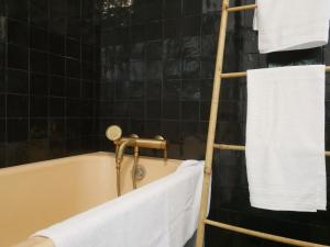 une baignoire avec un porte-serviettes et des serviettes. dans l'établissement Villa Kerandraon, à Gouesnach