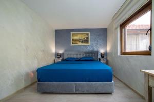 a bedroom with a bed with blue sheets and a window at Villa Sun Castle in Kotor