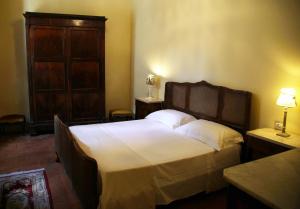 フォリーニョにあるLa Corteのベッドルーム1室(大型ベッド1台、木製キャビネット付)
