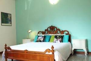 - une chambre avec un lit aux murs bleus dans l'établissement Il giardino dei fiori, à Mandello del Lario