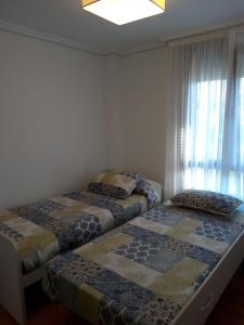 dwa łóżka ustawione w pokoju z oknem w obiekcie La LLamosa Beach&Nature w mieście Galizano