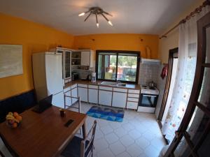 a kitchen with a table and a refrigerator at Pond and Pines, by nice house by the sea! in Epanomi +19 photos