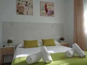 een slaapkamer met een wit bed en handdoeken bij Villa MyRuedo in Fuengirola