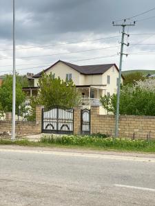 a house with a brick fence with a gate at Sultan Makan in Çuxuryurd