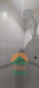 a bathroom with a shower with a sign on the wall at Hotel Casa Bonita in Campo Grande