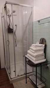 uma casa de banho com um chuveiro e uma pilha de toalhas em Casa Elvezia Guest House em SantʼElpidio a Mare