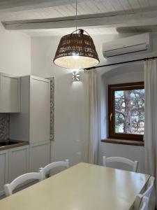 a kitchen with a white table and a light fixture at Appartamento il Caracolo a Cala Francese in La Maddalena