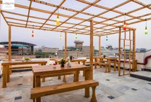 einem Pavillon mit Holztischen und -bänken auf einem Dach in der Unterkunft HOT - House Of Travellers Taj view in Agra