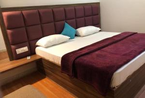 - une chambre avec un grand lit et une grande tête de lit dans l'établissement HOT - House Of Travellers Taj view, à Agra