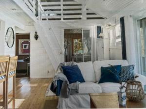 a living room with a white couch and blue pillows at Saltkällan Hällaviksvägen 11 in Uddevalla