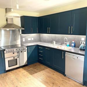 una cocina con armarios azules y un horno de fogón blanco en Ben View en Torridon