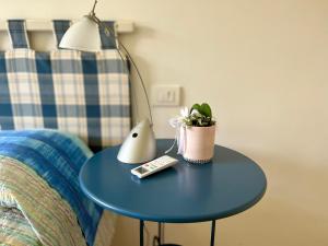 a blue table with a lamp and a remote control at Apartment Bardolino lake front in Bardolino