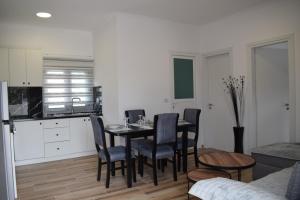 - une cuisine et une salle à manger avec une table et des chaises dans l'établissement Sunset Cottage 1, à Ksamil