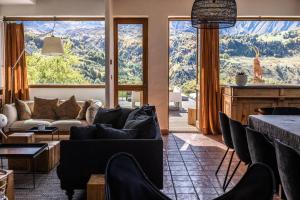 a living room with couches and a large window at Chalet d'Albiez in Albiez-Montrond