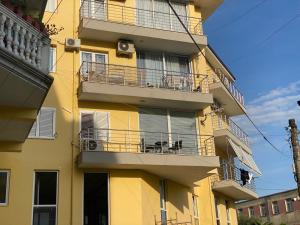 a yellow building with balconies and a balcony at White Luxury in Shkodër