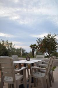 una mesa blanca y sillas en un patio en Sunset Cottage 1, en Ksamil