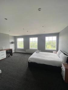 um quarto com uma cama grande e 2 janelas em Extra large 6 bed 7 bath townhouse in Manchester em Manchester