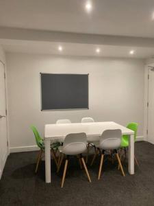 uma sala de reuniões com uma mesa branca e cadeiras verdes em Extra large 6 bed 7 bath townhouse in Manchester em Manchester