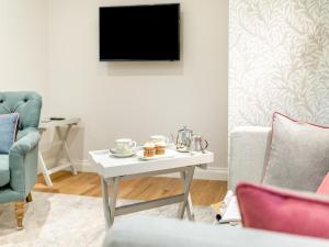 - un salon avec une table et une télévision dans l'établissement Annes Cottage, à Strines