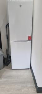 a white refrigerator freezer sitting in a room at Modern 2BD Flat in London