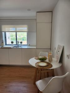 a small white kitchen with a table and chairs at Janela D’Ouro in Peso da Régua