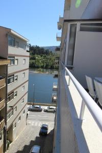 a balcony of a building with a view of a body of water at Janela D’Ouro in Peso da Régua