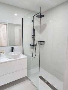 een witte badkamer met een douche en een wastafel bij Janela D’Ouro in Peso da Régua