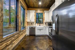 a kitchen with white cabinets and a stainless steel refrigerator at Brand New Luxury 2 Bedroom with Loft and Spa Sleeps 10 in Broken Bow