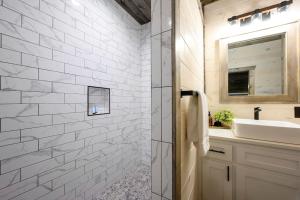 a white bathroom with a sink and a mirror at Brand New Luxury 2 Bedroom with Loft and Spa Sleeps 10 in Broken Bow +25 photos