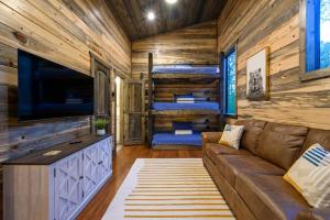 a living room with a couch and a tv and bunk beds at Brand New Luxury 2 Bedroom with Loft and Spa Sleeps 10 in Broken Bow